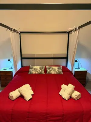 a bedroom with a red bed with two pillows at Chalet Le Palmette in Contrada Sauci Grande
