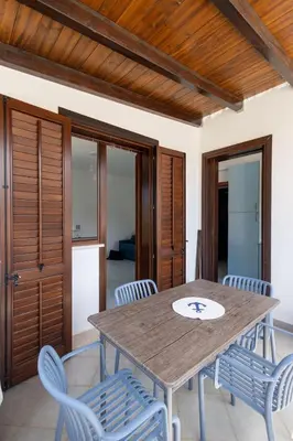 a dining room with a wooden table and chairs at Vista Monte Cofano in Castelluzzo