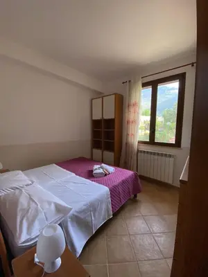 a bedroom with a bed and a large window at Baglio Cuttaia in Carini