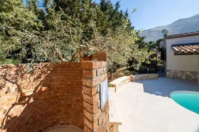 a brick wall next to a swimming pool at Exclusive Villa Eden in Castellammare del Golfo
