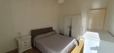 a small bedroom with a bed and a mirror at Magia del Sud in Palermo