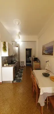 a kitchen and a dining room with a table and a table and chairs at Magia del Sud in Palermo