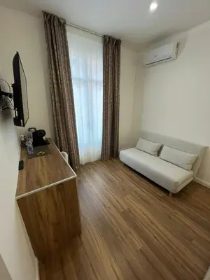 a small living room with a couch and a television at Maison Butera in Palermo