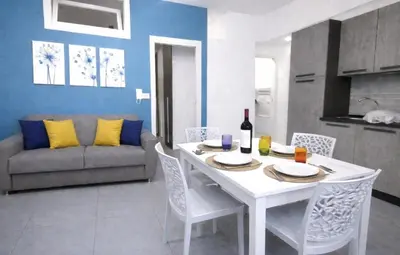 a living room with a white table and a couch at Aria di Paese in Altavilla Milicia