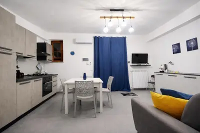 a kitchen with a table and chairs in a room at Aria di Paese in Altavilla Milicia