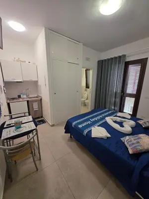 a bedroom with a blue bed with towels on it at Francesca Holiday Home in Castellammare del Golfo