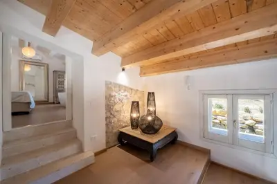 a room with wooden ceilings and a table with vases on it at Villa Baja Scopello in Balata di Baida