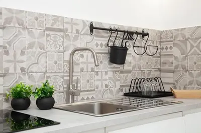 a kitchen with a stainless steel sink and tiles at Vicoloft al Capo in Palermo