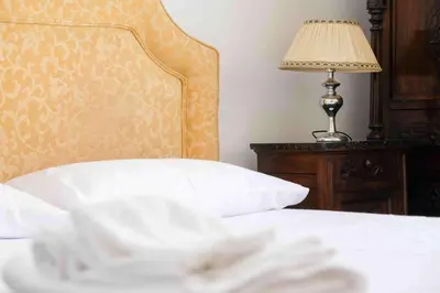 a bedroom with a bed and a lamp on a table at High-end apartment in the city center in Palermo