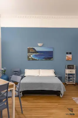 a bedroom with a bed and a painting on the wall at Al Mondellu apt Verosicily in Palermo