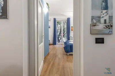 a room with a hallway with a blue couch at Al Mondellu apt Verosicily in Palermo