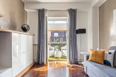 a living room with a couch and a large window at Sunny Suite Palermo in Palermo