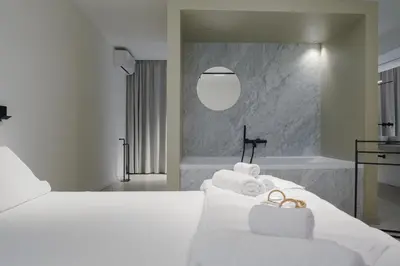a bedroom with a white bed and a bath tub at Idro Luxury Suite in Palermo