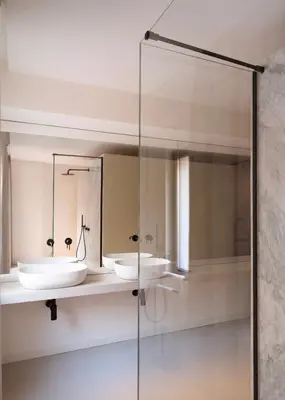 a bathroom with two sinks and a glass shower at Idro Luxury Suite in Palermo