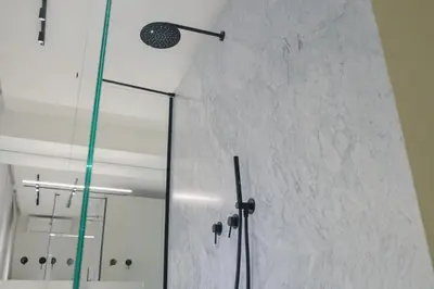 a shower in a bathroom with a glass door at Idro Luxury Suite in Palermo