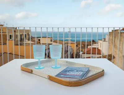 a tray with two glasses and a book on a table at Terrazza Marconi in Castellammare del Golfo