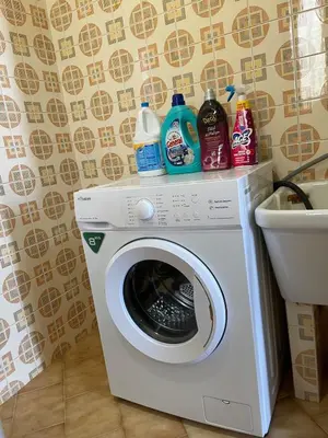a washing machine with cleaning products on top of it at Sea view terrace house in Alcamo