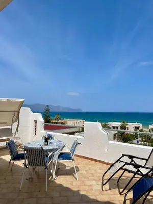 a patio with a table and chairs and the ocean at Sea view terrace house in Alcamo