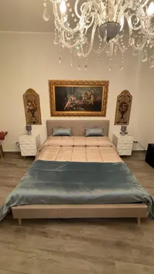 a bedroom with a large bed with a chandelier at Vanila Dream's House in Palermo