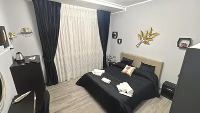 a bedroom with a black bed with towels on it at Vanila Dream's House in Palermo