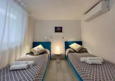 a bedroom with two beds and a window at Marina Beach Apartments in Alcamo