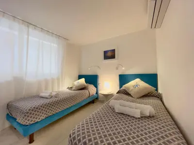 two beds in a bedroom with blue and white at Marina Beach Apartments in Alcamo