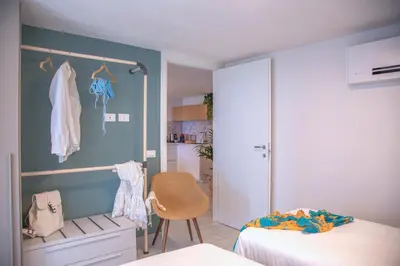 a bedroom with two beds and a lamp at Marina Beach Apartments in Alcamo
