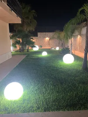 a garden with lights on the grass at night at Nereide home 350 sqm with large garden in Balestrate