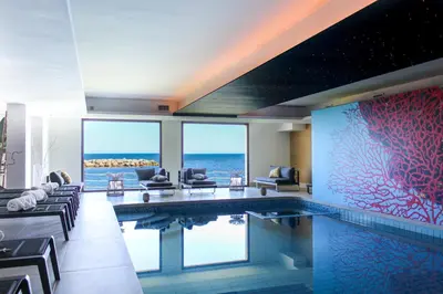 a hotel room with a swimming pool with a view of the ocean at Hotel Tonnara Trabia in Trabia