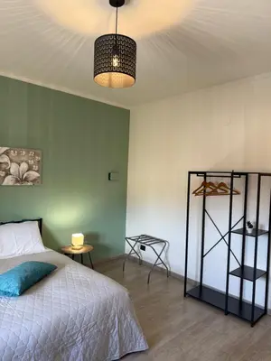 a desk in a bedroom with a blue chair at Kayu Home in Palermo