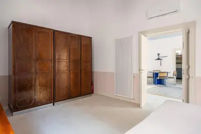 a large wooden cabinet in a room with a table at Casa Dara By DomuSicily in Palermo