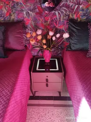 a table with a vase on it next to a bed at Nanà in Movida in Palermo