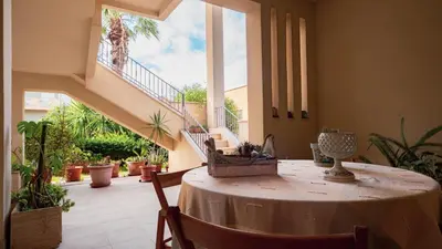 a room with a table with chairs and a staircase at Agelina square Home Gibellina in Nuova Gibellina