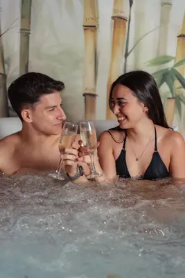 a man and woman sitting in a bathtub with wine glasses at La Piazzetta Sea Rooms in Balestrate
