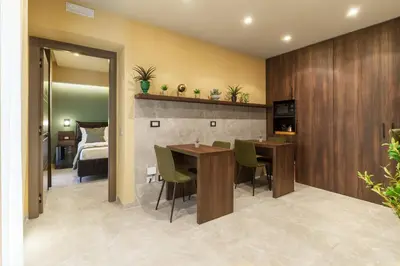 a room with a table and chairs and a bedroom at La Piazzetta Sea Rooms in Balestrate