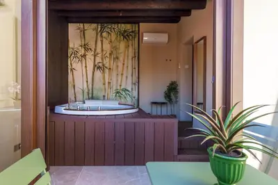 a room with a bathtub with palm trees on the wall at La Piazzetta Sea Rooms in Balestrate