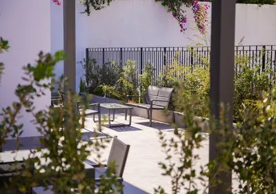 a patio with chairs and a table in a garden at Solemar Sicilia - Casa Belle in Palermo