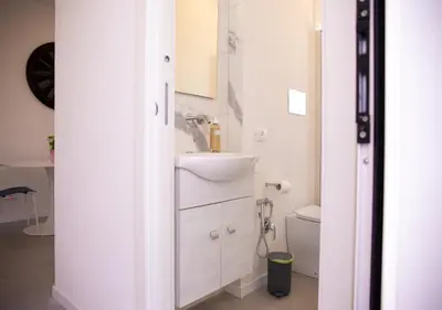 a white bathroom with a sink and a toilet at Solemar Sicilia - Casa Belle in Palermo