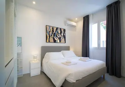a bedroom with a white bed and a window at Solemar Sicilia - Casa Belle in Palermo