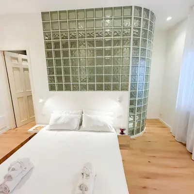 a bedroom with a white bed and a glass wall at Palazzo Crisafulli Suite in Palermo