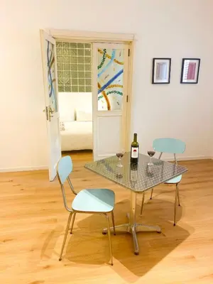 a table with two chairs and a bottle of wine at Palazzo Crisafulli Suite in Palermo