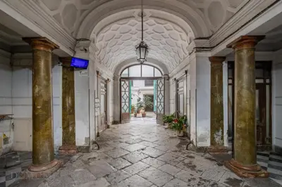 an empty hallway in a building with columns at Carducci Apartment By DomuSicily in Palermo