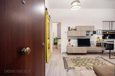 an open door to a living room with a kitchen at Carducci Apartment By DomuSicily in Palermo