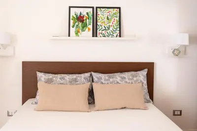 a bedroom with a bed with two pictures above it at The Nest Maqueda in Palermo