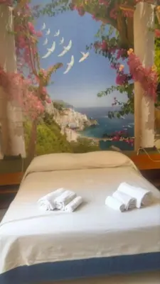 a bedroom with a painting of a bed with towels at Casa degli Angeli Castellammare del Golfo TP Sicilia in Castellammare del Golfo