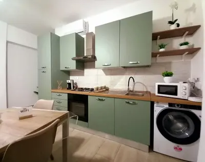a kitchen with a table and chairs and a sink at Blossom House in Isola delle Femmine