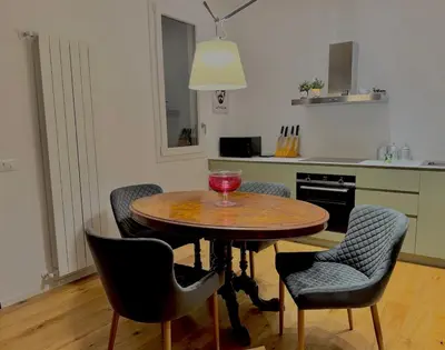 a kitchen with a wooden table with chairs and a red glass on it at Haus Mignon - Bright flat in Palermo Center in Palermo