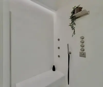 a bathroom with a white wall and a bath tub at Haus Mignon - Bright flat in Palermo Center in Palermo