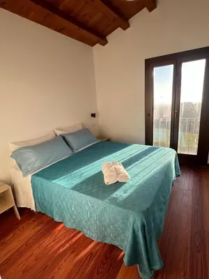 a bedroom with a bed with a blue blanket on it at RossoScirì in Calatafimi