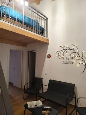 a living room with two chairs and a staircase at Appartamento La Perla bianca in Palermo